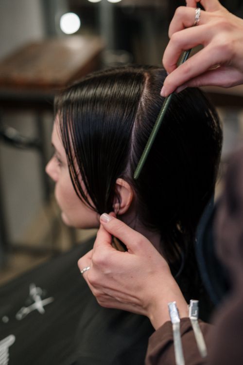 Hair colorist applying professional hair color in salon chair