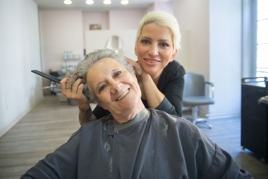 Smiling senior woman with beautifully styled gray hair at salon